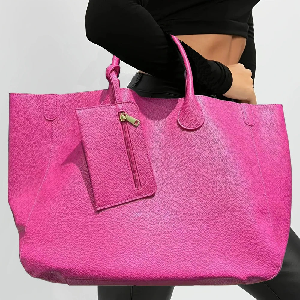 Person holding a bright pink tote bag with a visible brand tag.